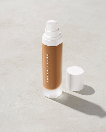 open bottle of Fenty Beauty Pro Filt'r Soft Matte Longwear Foundation with pump dispenser in shade 385 on concrete background