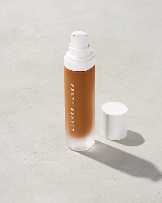 open bottle of Fenty Beauty Pro Filt'r Soft Matte Longwear Foundation with pump dispenser in shade 440 on concrete background