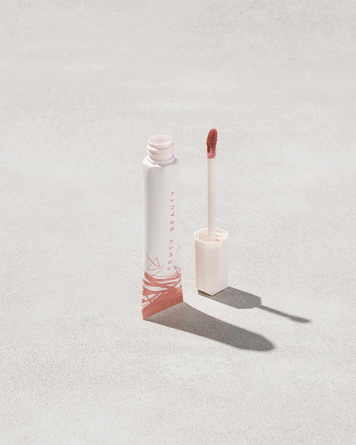 Open tube of Pro Kiss'r Luscious Lip Balm in shade Latte Lips on grey background.