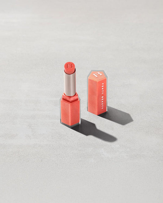 Open shot of Gloss Bomb Stix Shimmer in shade See You in Maui on a concrete background.