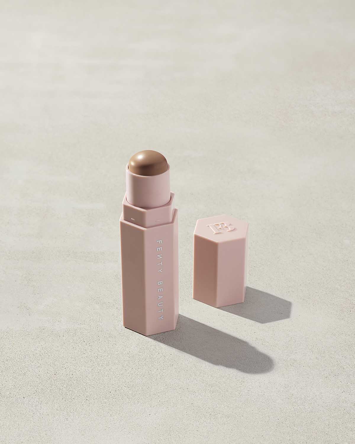 Opened Match Stix Contour Skinstick in the shade Amber Suede container on a grey background.