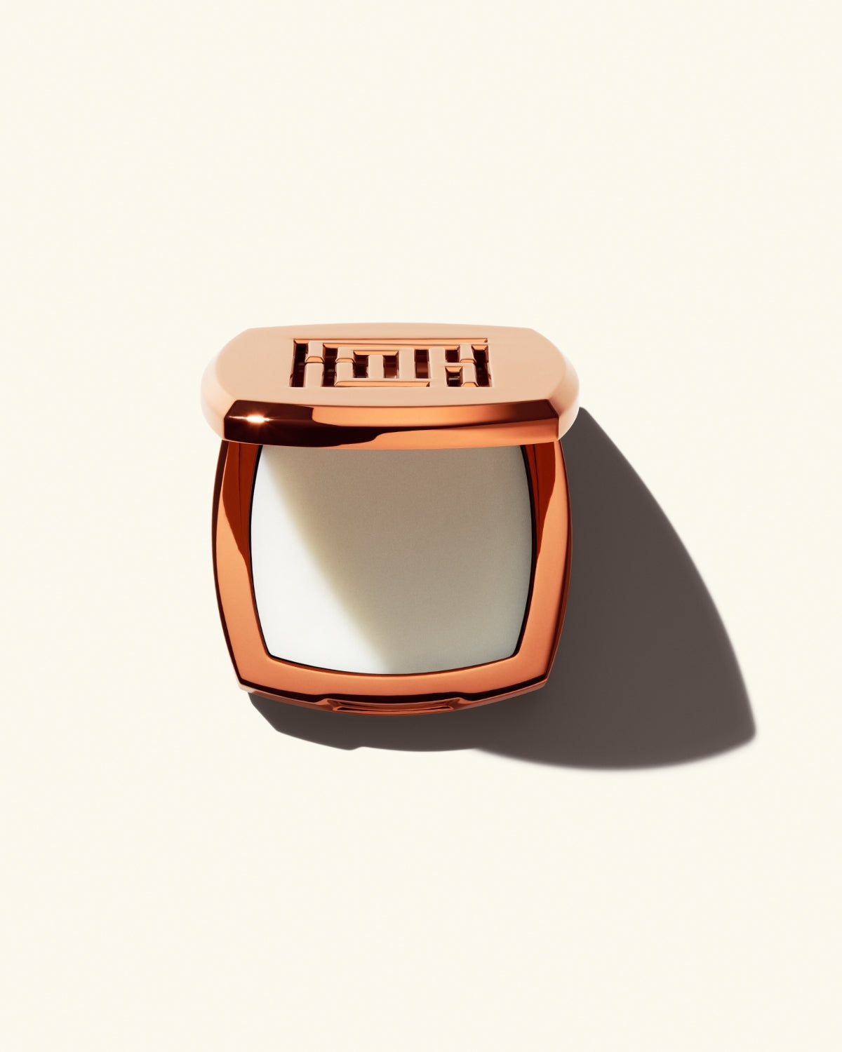 Open shot of Fenty Fragrance Solid Parfum on a cream background